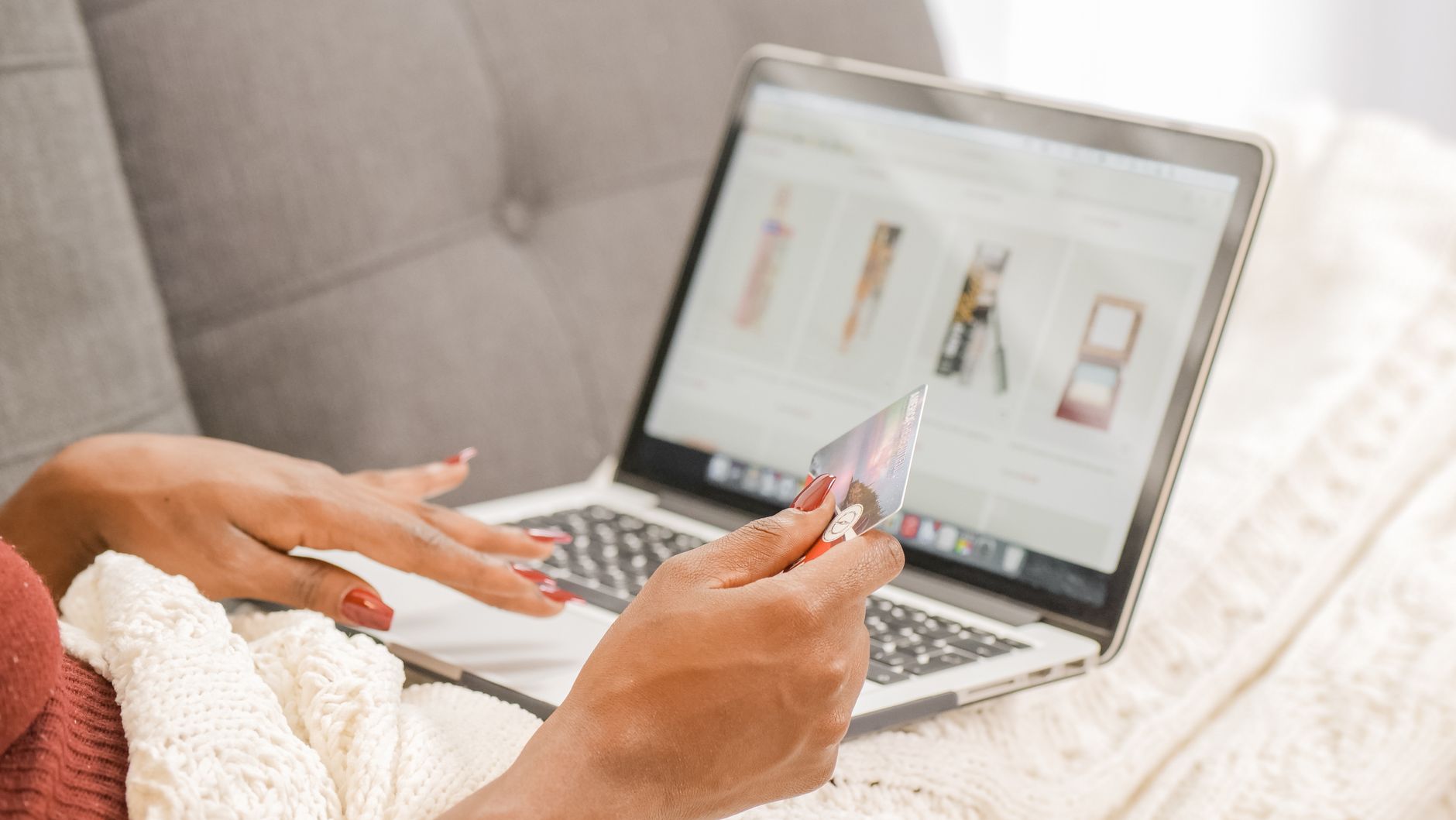 Pessoa fazendo compra online no notebook com cartão na mão